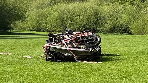 Burnt out car in field